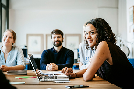 3 young medical students at table with laptop.