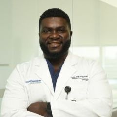smiling black man with arms crossed wearing white lab coat