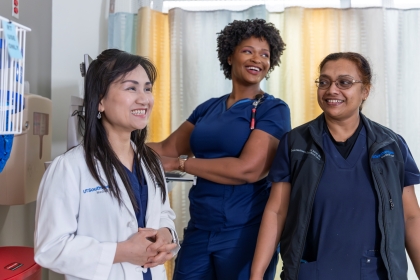 3 smiling women in hospital setting.
