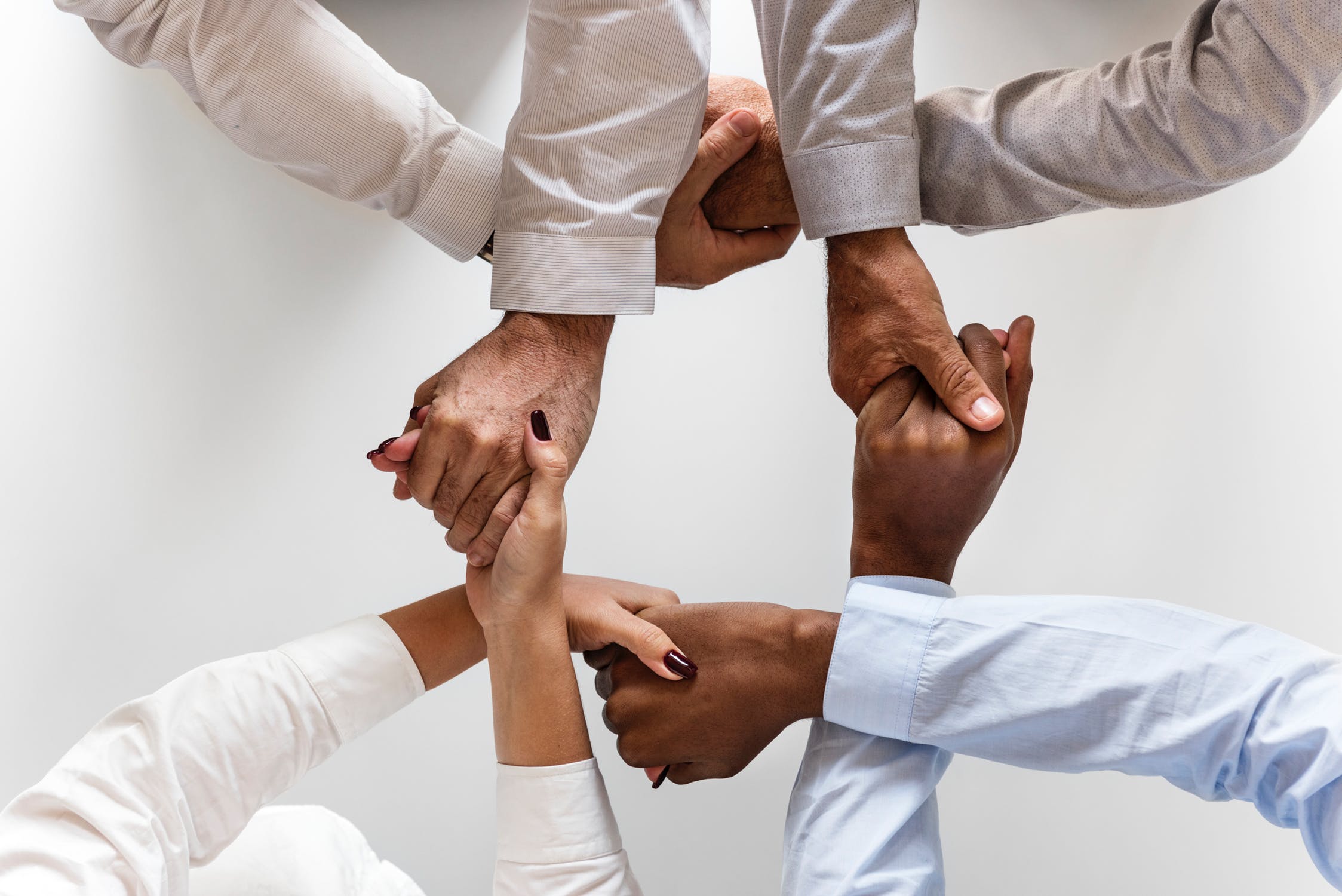 A photo of people with different skin colors holding hands