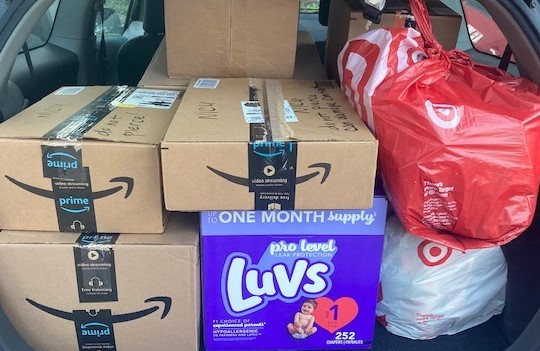 stacks of Prime cardboard boxes, Luvs diaper box, 2 plastic shopping bags