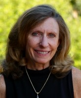 Kathy Peters: woman with long grey/brown hair wearing black sleeveless top
