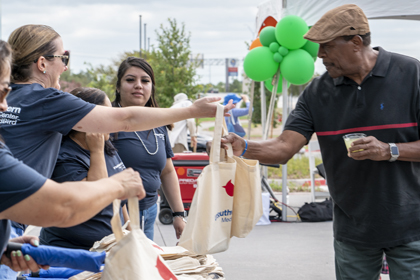 UTSW employees passing out food bags at the HealthFest
