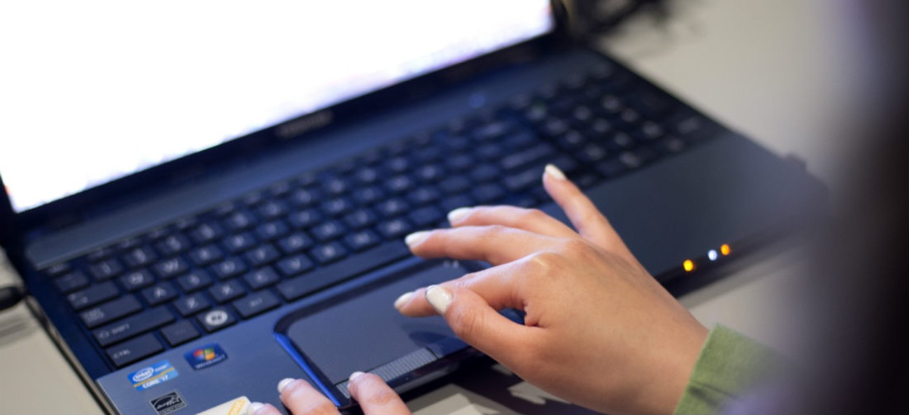 person hands typing at a laptop