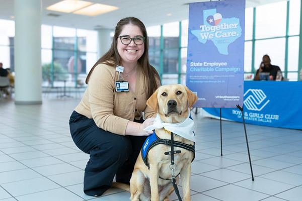 Female poses with yellow lab, Tia