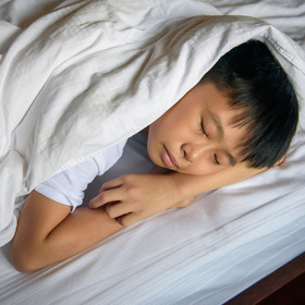 Photo of a child sleeping under covers