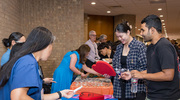 Attendees check out different booths and grab swag at the event.
