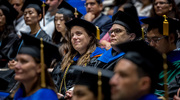 At center, Amy Hughes, Ph.D., Associate Professor of Epidemiology, looks on with pride as this year’s graduates receive their diplomas.