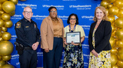 Platinum pin recipient Viji John with the University Police Department takes a photo with her certificate beside, from left, University Police Chief Marcus Lewis, M.A.; Tiffany Thomas, Supervisor of Electronic Security Administration; and Ms. Crawford.