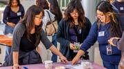 Harmony Science Academy student Cristol Garcia, right, stretches slime until it snaps. During the exercise, students tested how changes in the components of the ECM can make it softer or stiffer, or easier to stretch.