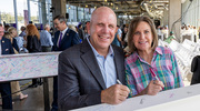 Richard Greth and Lyndal Stephens Greth smile for a quick photo before inscribing their names on one of the beams.
