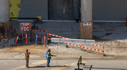 The beam headed for placement atop the hospital is prepped by construction workers.