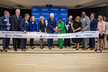 9 men and women, 3 with large scissors cutting a white ribbon. Texas Behavioral Health Center and UTSW logos.