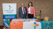 Judith Ramos, Chair of the Hispanic-Latino Alliance Business Resource Group (BRG), and Ruben Esquivel, M.B.A., Vice President for Community and Corporate Relations, prepare to hand out goodies for attendees at the BRG booth.