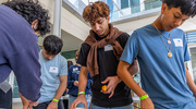 From left: Harmony Science Academy students Mr. Hashimi, Mr. Gurbuz, and Mr. Badillo stretch slime until it breaks as part of an exercise on the structure and function of the extracellular matrix (ECM), the connective tissue that provides the physical scaffolding for cells.