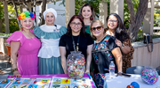 Members of the Hispanic-Latino Alliance BRG, in festive attire, gather for a group photo at their booth.