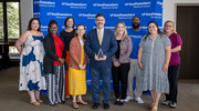 Mr.&nbsp;Fleming, center, a Senior Regulatory Associate in the Harold C. Simmons Comprehensive Cancer Center&rsquo;s Clinical Research Office, beams proudly holding his award while surrounded by colleagues. From left: Stephanie Lovely, Yolanda Pitts, Erin Willams, Patty Waldrop, Kelly Kyle, Jeremie Golden, Ellen Siglinsky, and Tianna Petersen.