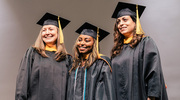 Master of Physician Assistant Studies graduate Mekdes Abera, center, stands on stage for a commemorative photo with program faculty after receiving her diploma.
