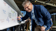 Jonathan Efron, M.D., Executive Vice President for Health System Affairs at UT Southwestern, autographs one of the beams.