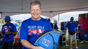 Jonathan Efron, M.D., Executive Vice President for Health System Affairs, shows off the new UTSW Heart Walk sling bags.