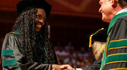 Bundu Ezenwukwa, M.D., left, shakes hands with keynote speaker Chancellor John M. Zerwas, M.D., as she receives her diploma.