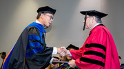 Biomedical Engineering graduate Lixiang Guo, Ph.D., receives his diploma from UT Southwestern President Daniel K. Podolsky, M.D.