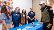 Members of UT&nbsp;Southwestern’s Employee Advisory Council, handing out free goodies at their booth, greeted an event attendee.