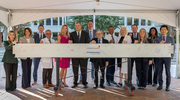 UT Southwestern leaders, including Dr. Podolsky (center), stand behind one of the ceremonial beams they signed to celebrate the milestone.