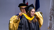 Emily Levy Kamugisha, M.D., M.S.C.I., Associate Professor of Family and Community Medicine, is hooded by Saad B. Omer, M.B.B.S., M.P.H., Ph.D., Dean of OSPH.