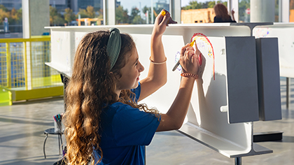 Girl signs white beam.