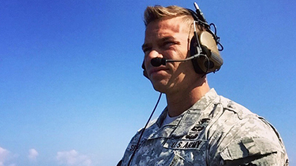Man in military fatigues wearing a headset.