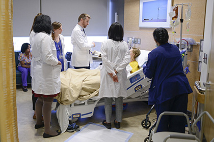 6 health care workers visit with a hospitalized patient.