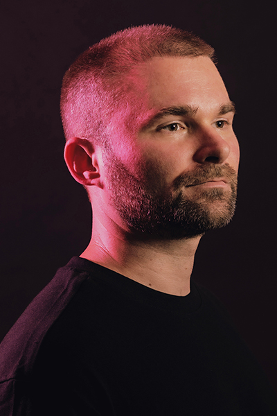 headshot of Calvin Sprague man with buzzcut hair on black background