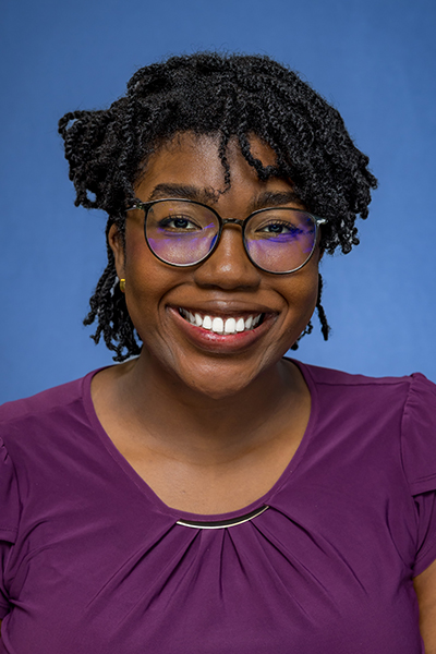 headshot of smiling woman with short black hair and glasses