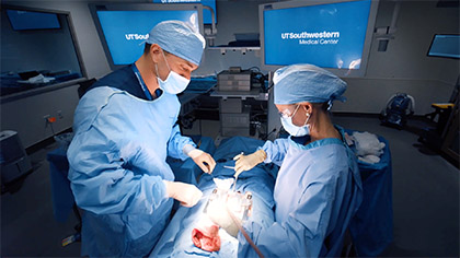 A man and a woman in surgical gowns perform a simulated surgery in the Simulation Center