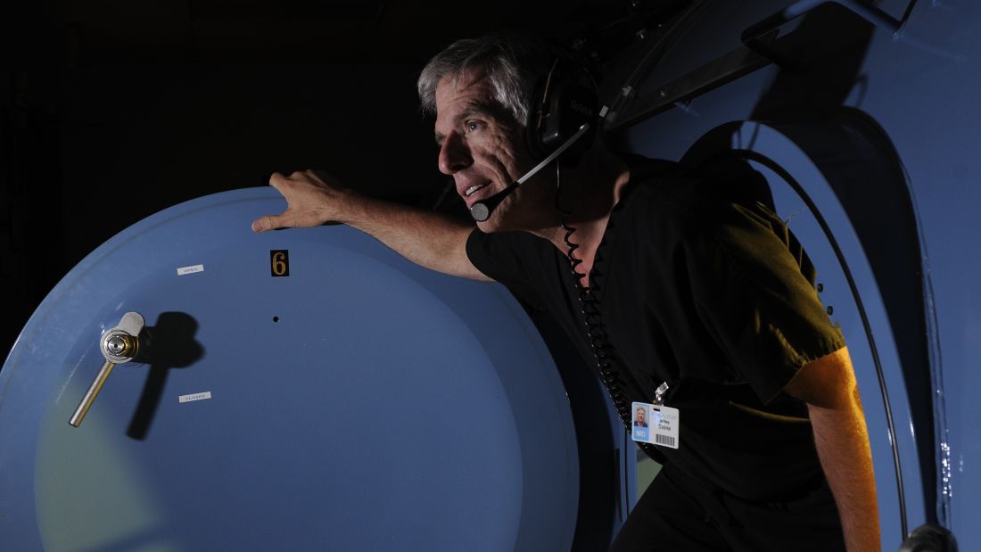 blue hyperbaric chamber with man exiting