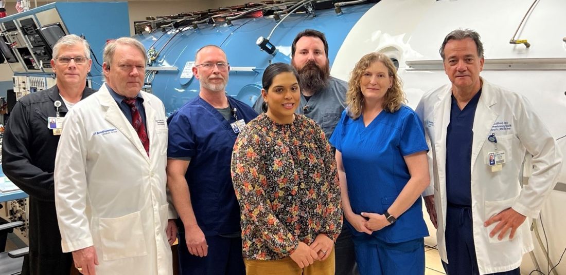 people standing in front of hyperbaric chamber
