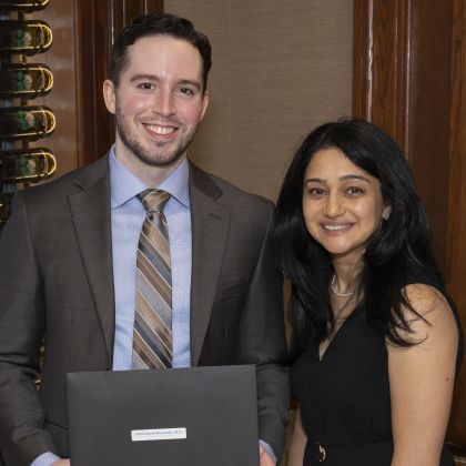 Jared Alexander, M.D. holding a diploma with Aditee Ambardekar, M.D.