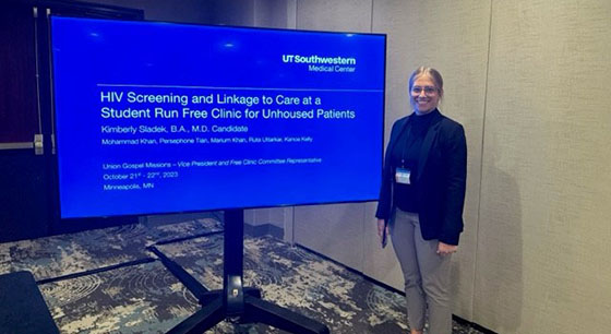 Med students standing with their research poster at the student run free clinics national conference