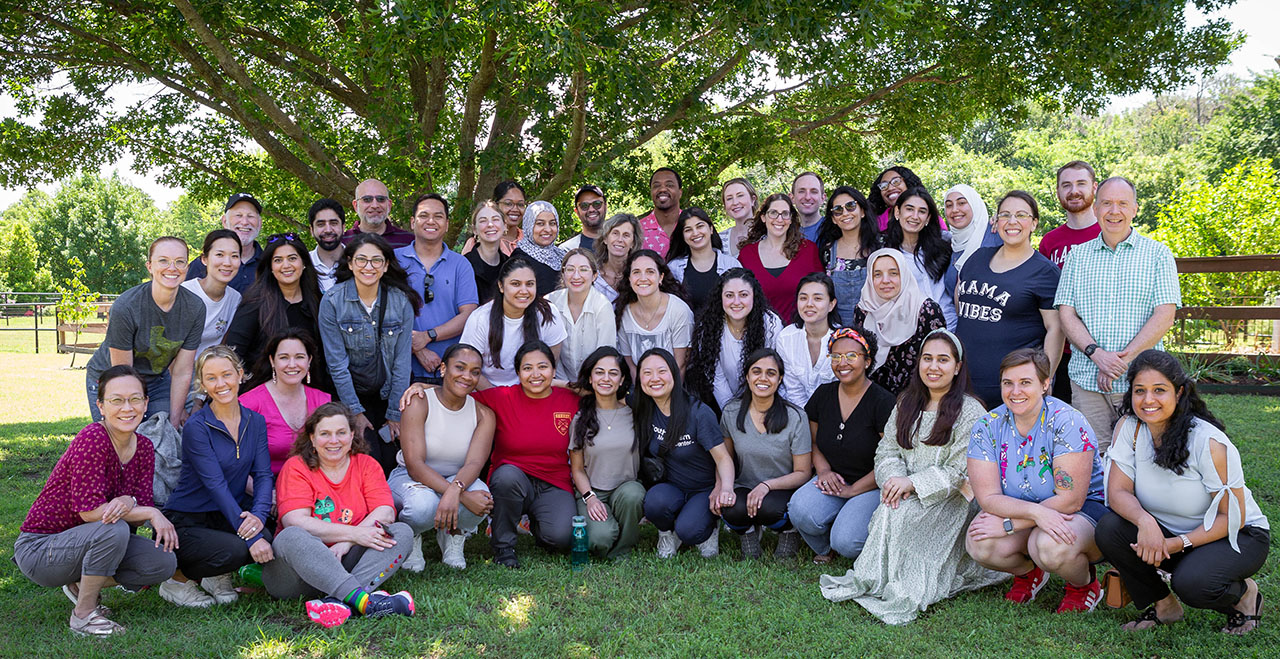 Group Photo of Residents and Faculty in a field in front of a large tree