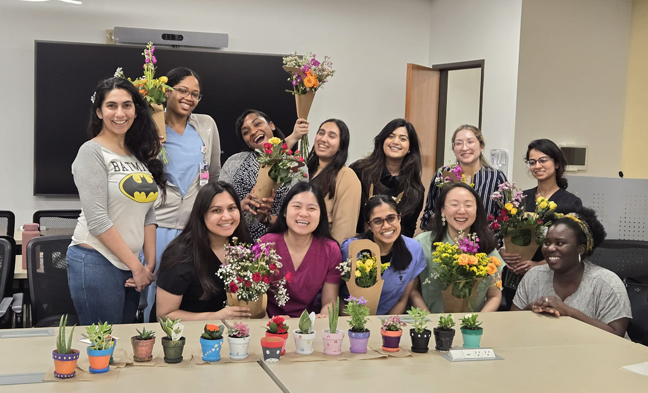 A group of resident holding flowers and potted plants
