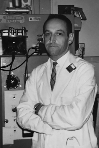 Dr. Marvin Siperstein standing infront of a mechanical device