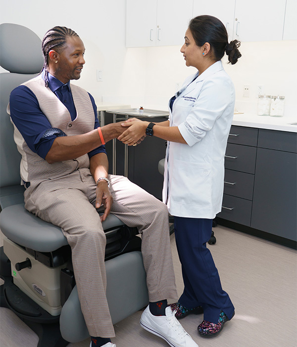 a doctor greeting a patient in an exam room