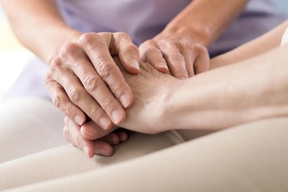 two people holding hands in comfort
