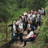 A Global Health & Disparities group photo on a trail in front of a green valley