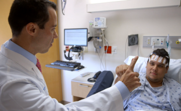 a physician checking on a patient in a hospital bed