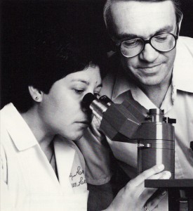 Two physicians looking through a microscope