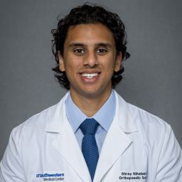 Male Orthopaedic Surgery Resident wearing a white coat