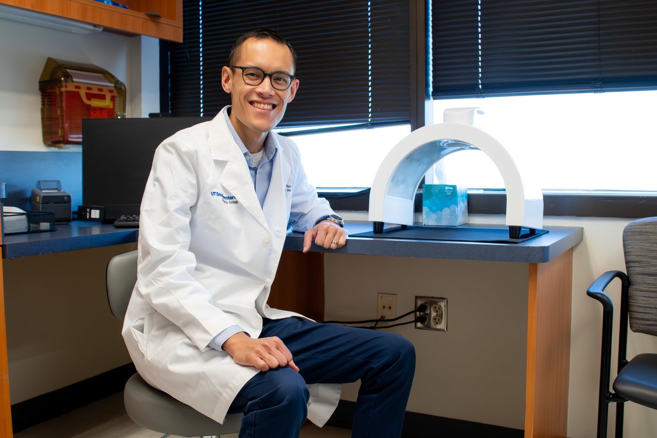 Dr. Chow posed with a white Allergy and Immunology machine