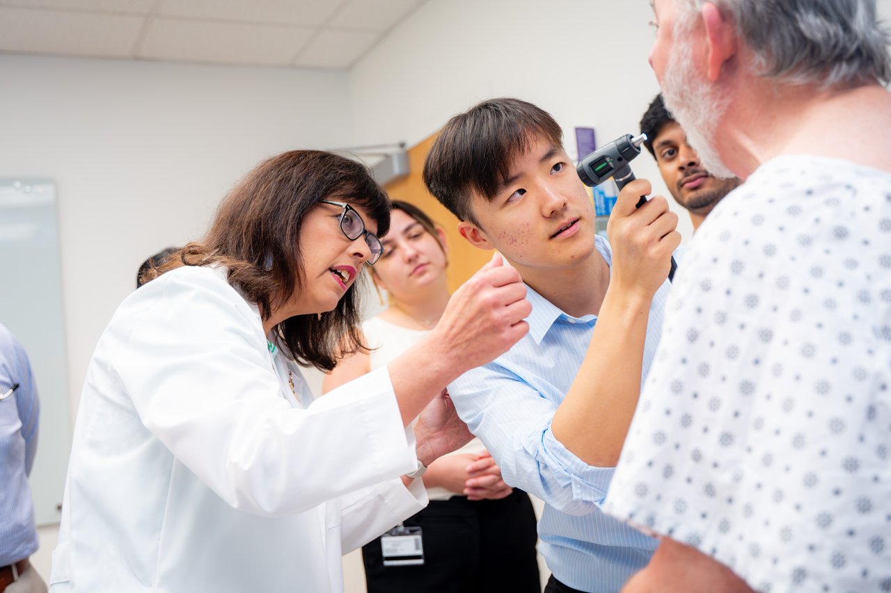Dr. Mihalic teaching medical students how to do a checkup on a fake patient